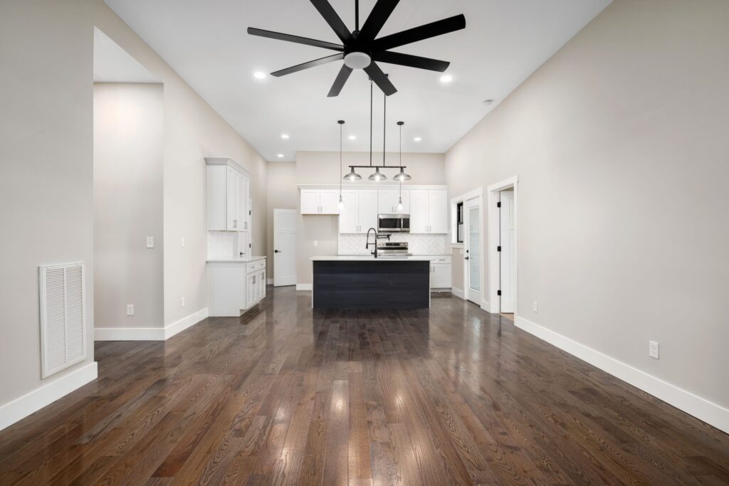Spacious modern kitchen featuring hardwood floors, ceiling fan, and sleek cabinetry, perfect for interior design inspiration.