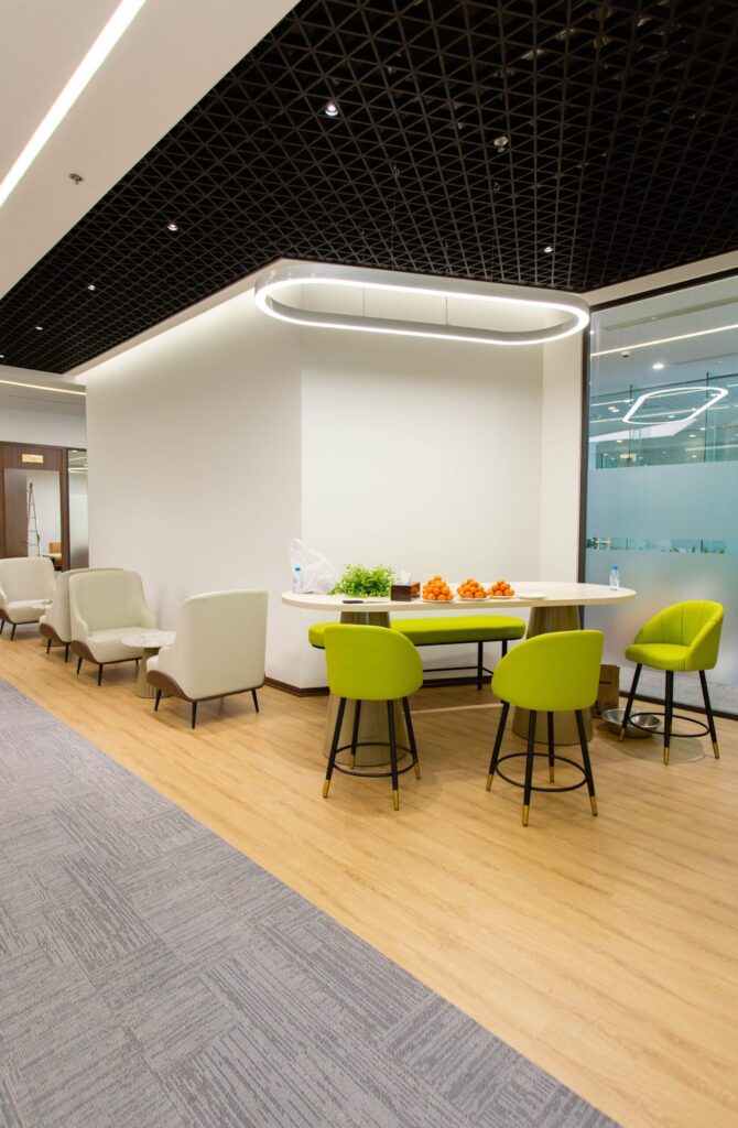 A stylish office interior featuring a contemporary seating area with green and white chairs.