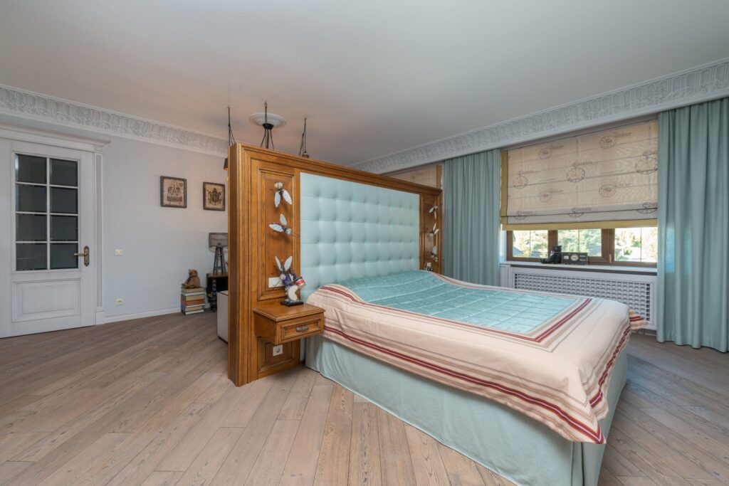 Stylish bedroom interior with wooden elements and soft pastel decor.